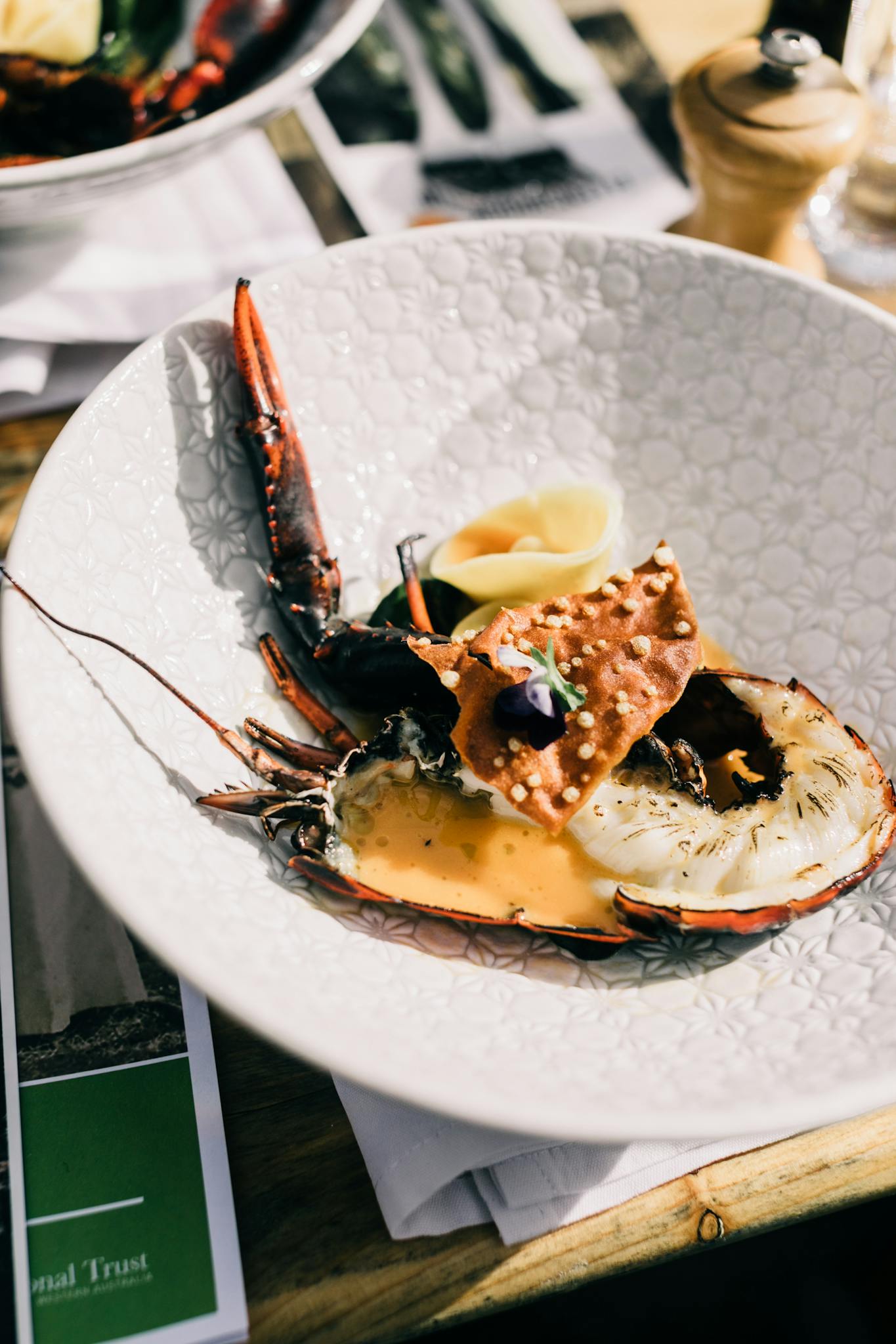 From above of appetizing fresh lobster served on white plate on table near seasoning n luxury restaurant with gourmet food